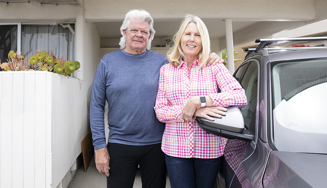 duwayne and jan dunham stand next to their vehicle