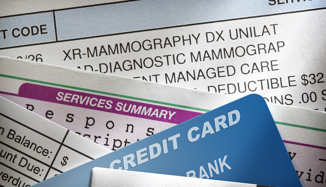 A closeup of a credit card and a stack of medical bills.
