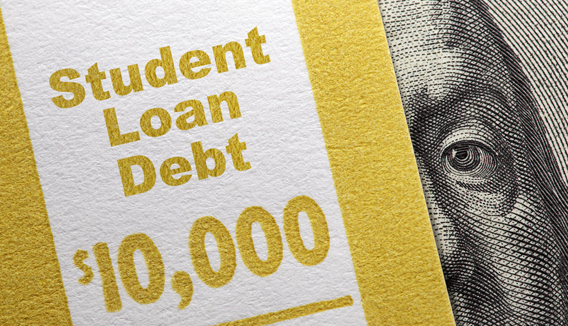 Parte de un billete de 100 dólares con un ojo de Benjamin Franklin cubierto bajo un texto que dice deuda de préstamo estudiantil  10 mil