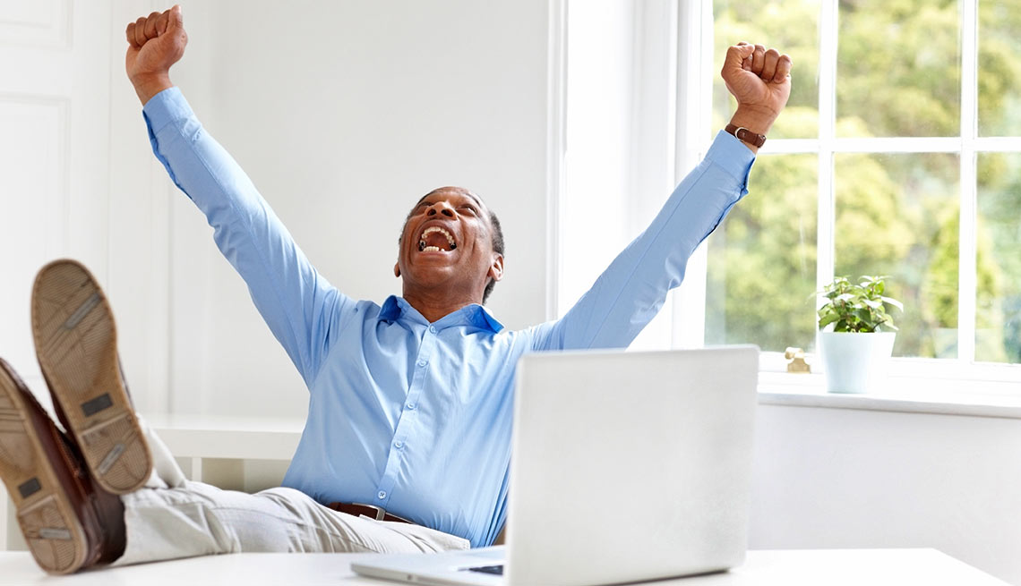 Seven Ways to Save More - Excited mature businessman celebrating success at his desk