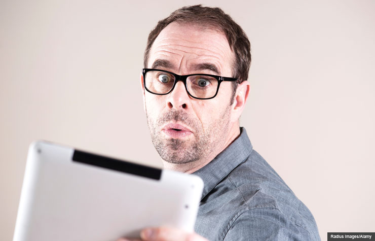 Surprised man with electronic tablet, Protect your personal information after an ended relationship (Radius Images/Alamy)