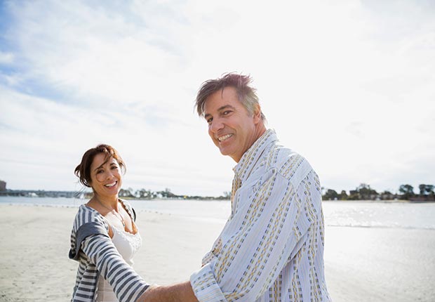 Portrait of smiling mature couple on beach vacation (Hero Images/Getty Images)