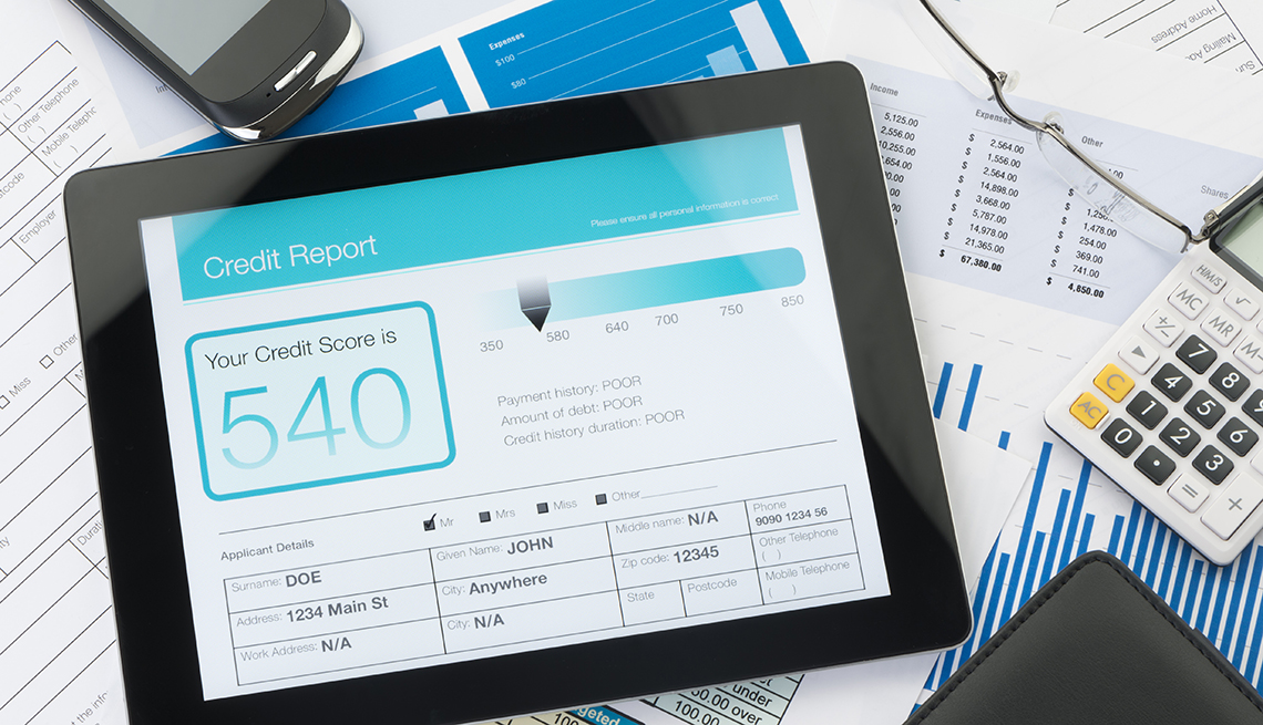 Reporte de crédito en una tableta sobre cuentas en papel.