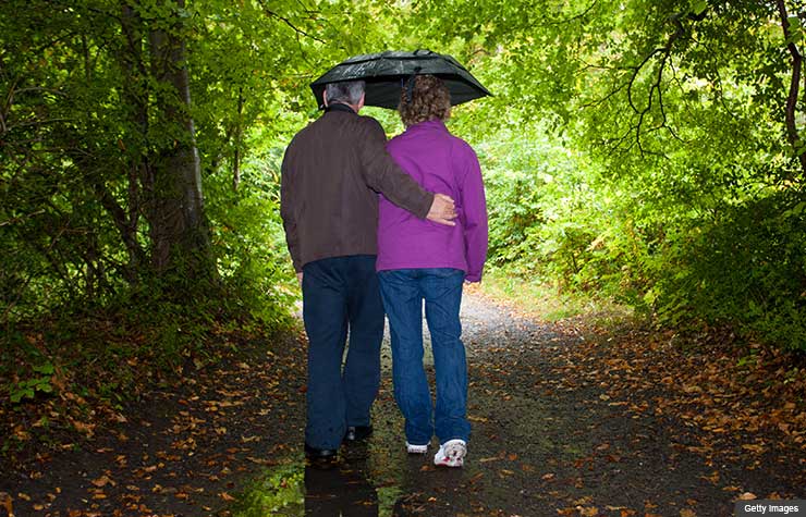 financial planning children family with special needs disability disabled investment advice walk in rain couple umbrella woods jane bryant quinn (Getty Images)