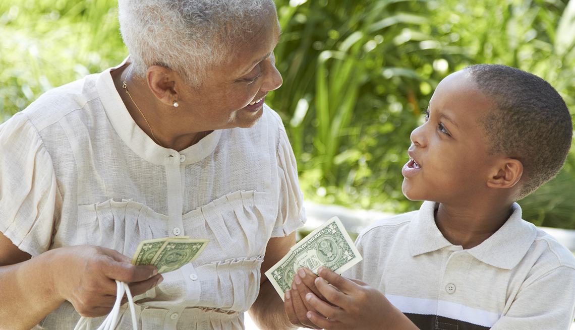 Teaching Your Grandkids About Financial Literacy - grandma handing her grandson money
