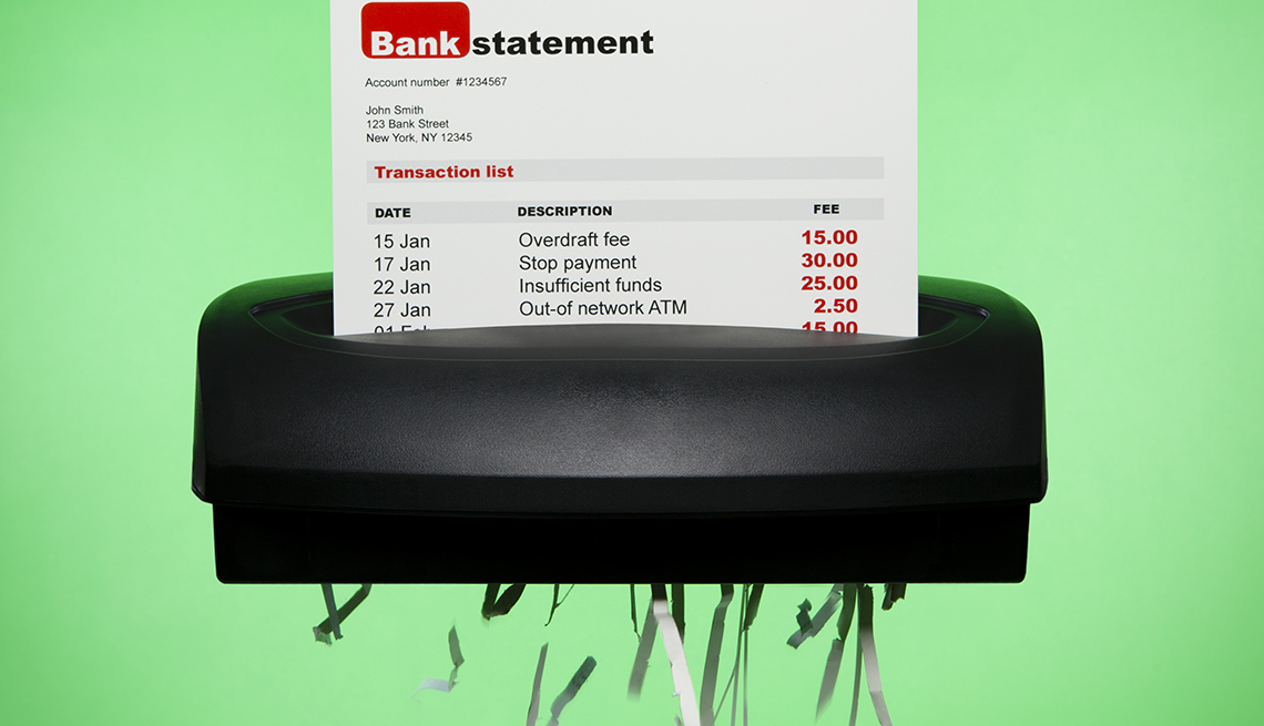 bank statement showing various bank fees being shredded on green background