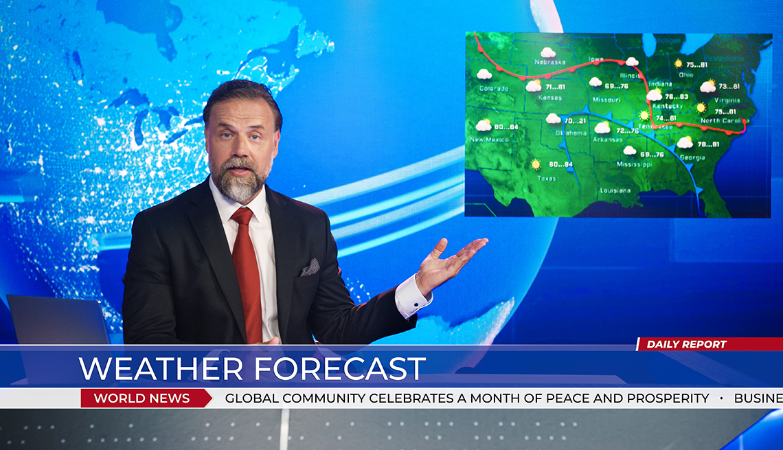 tv weather forecaster gesturing towards forecast map