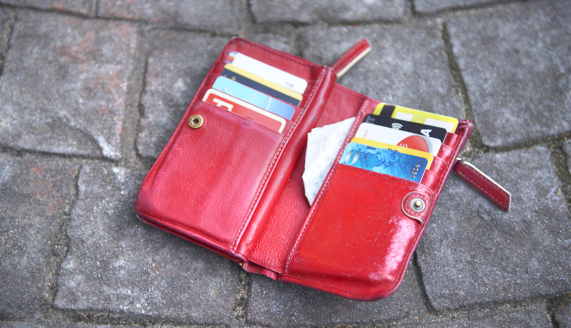 an open wallet on the ground with credit cards and receipts in it