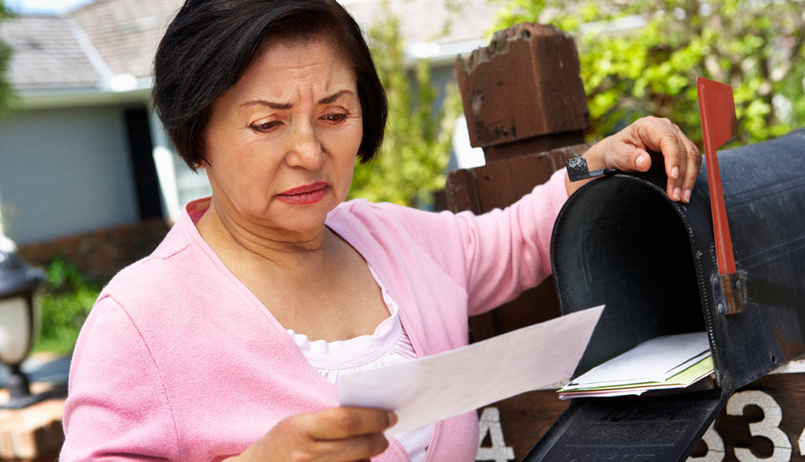 Mujer mayor chequeando el buzon de correo - Estafa impostor del IRS