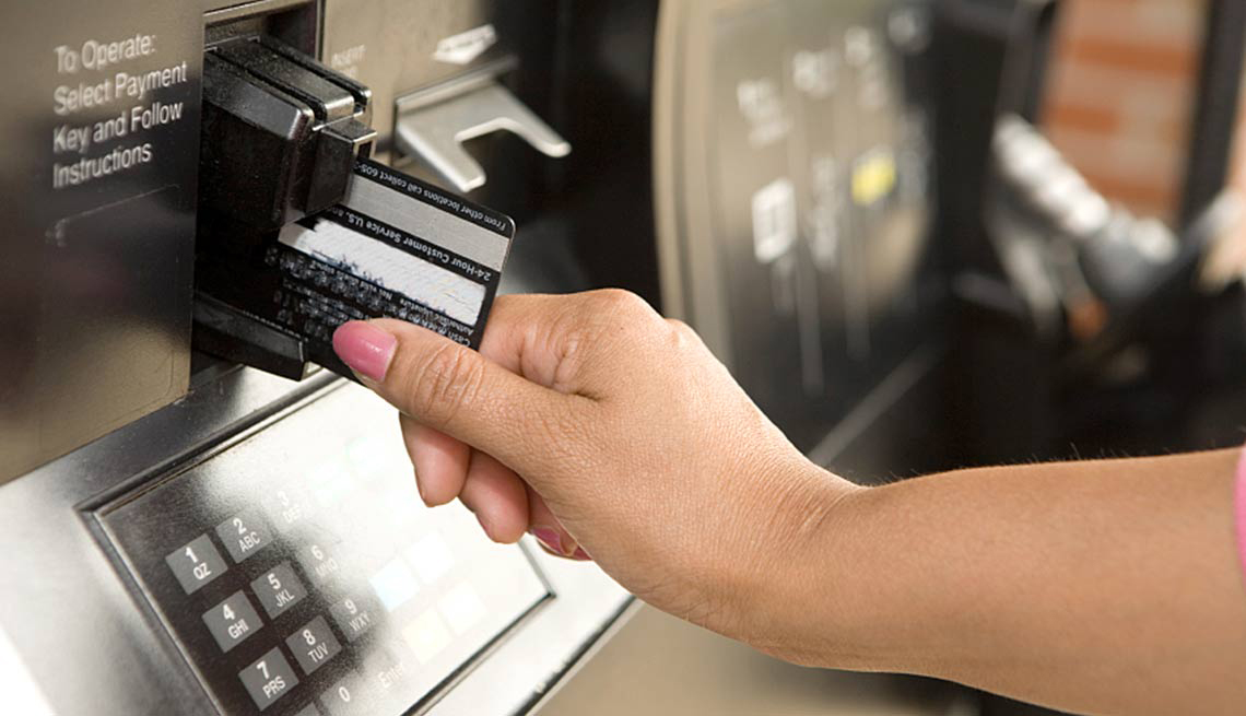 Mano de una mujer colocando una tarjeta de débito en una máquina pública.