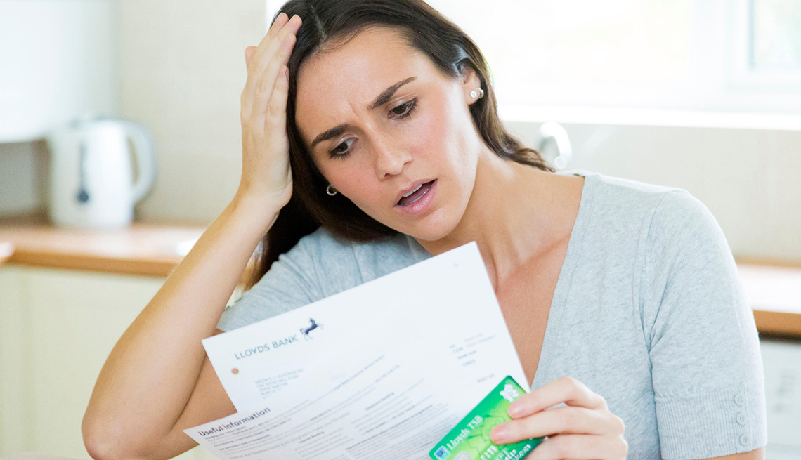 Worried woman reviews her bank statement, afraid that there may be fraudulent charges.