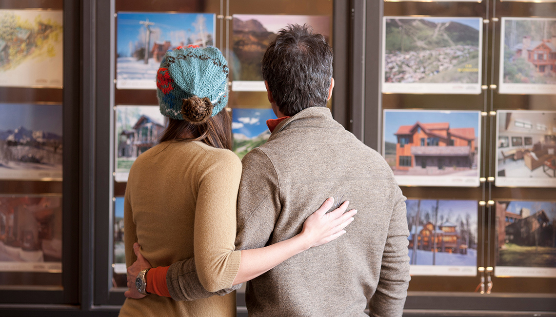 Couple looking through holiday vacation packages at travel agents office