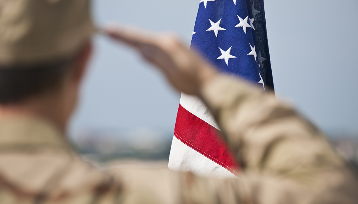 Militar saludando la bandera de Estados Unidos.