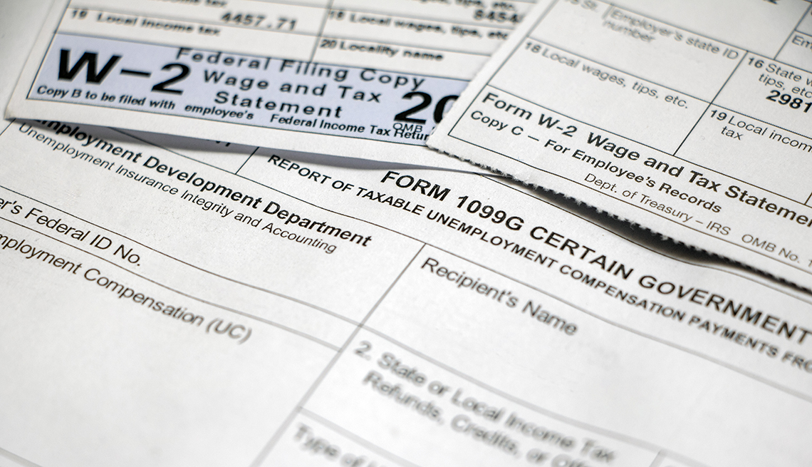 Closeup of Form 1099G Certain Government Payouts with W-2 forms overlapping on top.