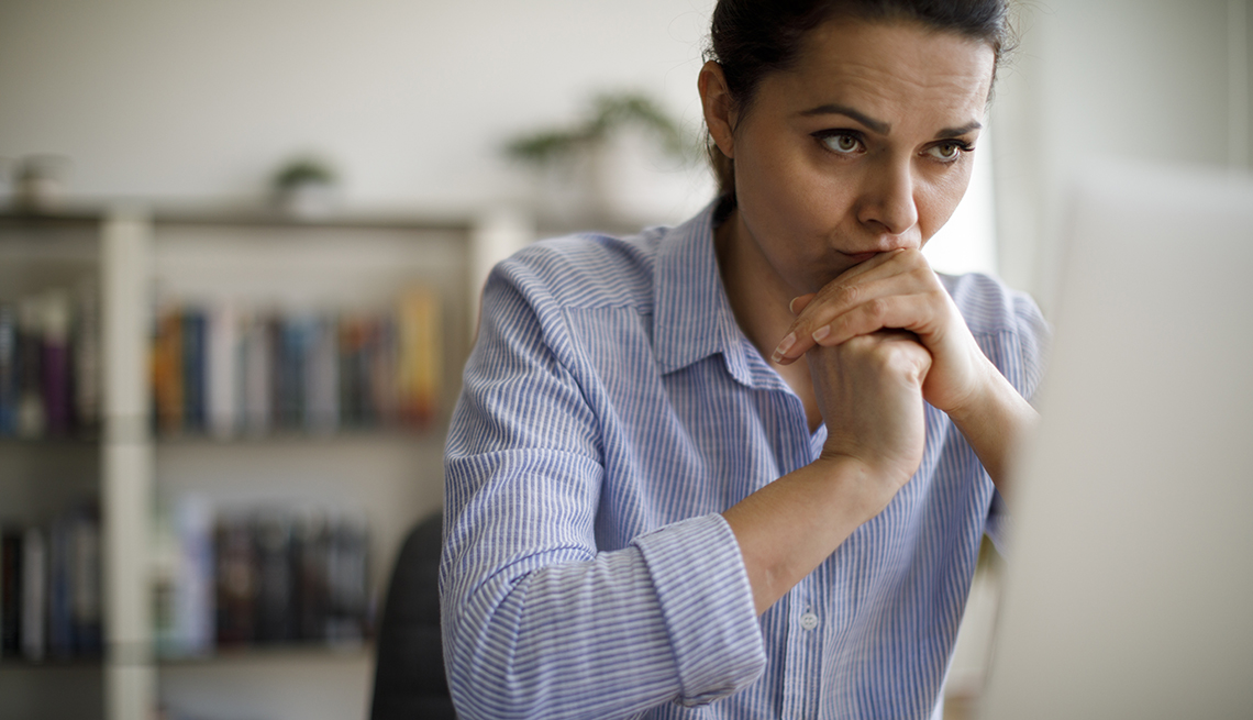 Worried woman looking at computer screen