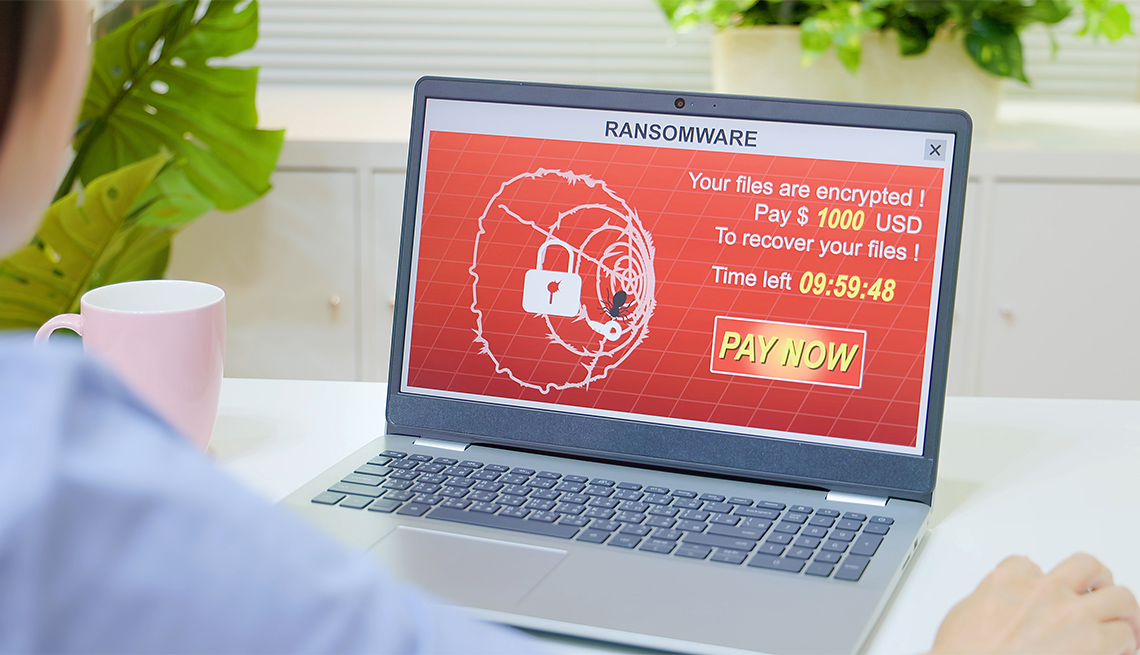 ransomware attack displayed on a woman's laptop screen