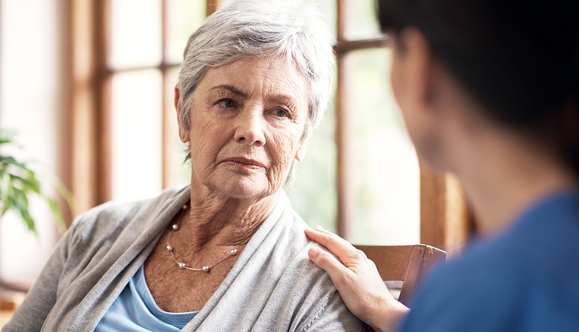 Shot of a young nurse talking with an elderly woman in a retirement home