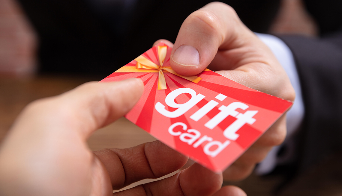 La mano de un ejecutivo entrega a otra persona una tarjeta de regalo