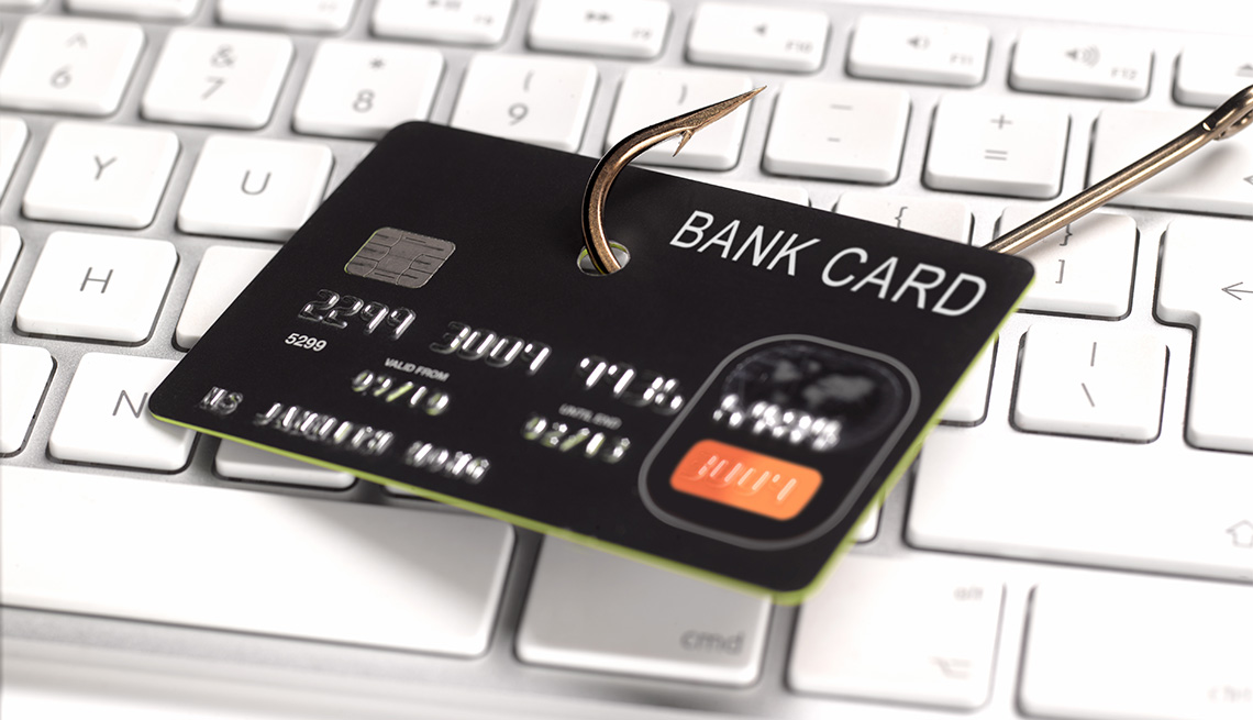 credit card with a hook on it, displayed on a keyboard signifying phising scam