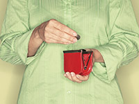 Woman putting a coin into a red purse