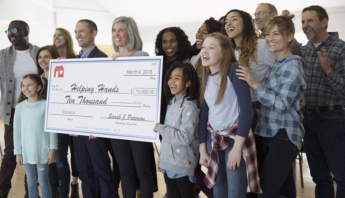enthusiastic community posing with large donation check 