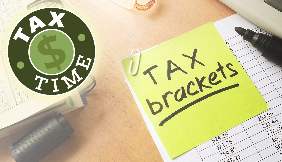 tax brackets post it note on financial spreadsheet