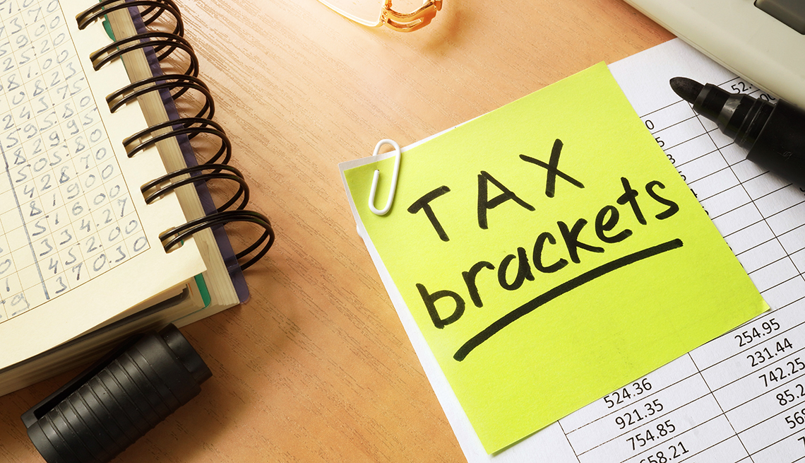 tax brackets post it note on financial spreadsheet