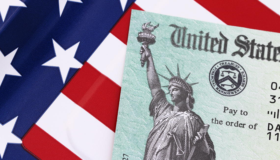 Cheque del IRS con una bandera de Estados Unidos en el fondo. 