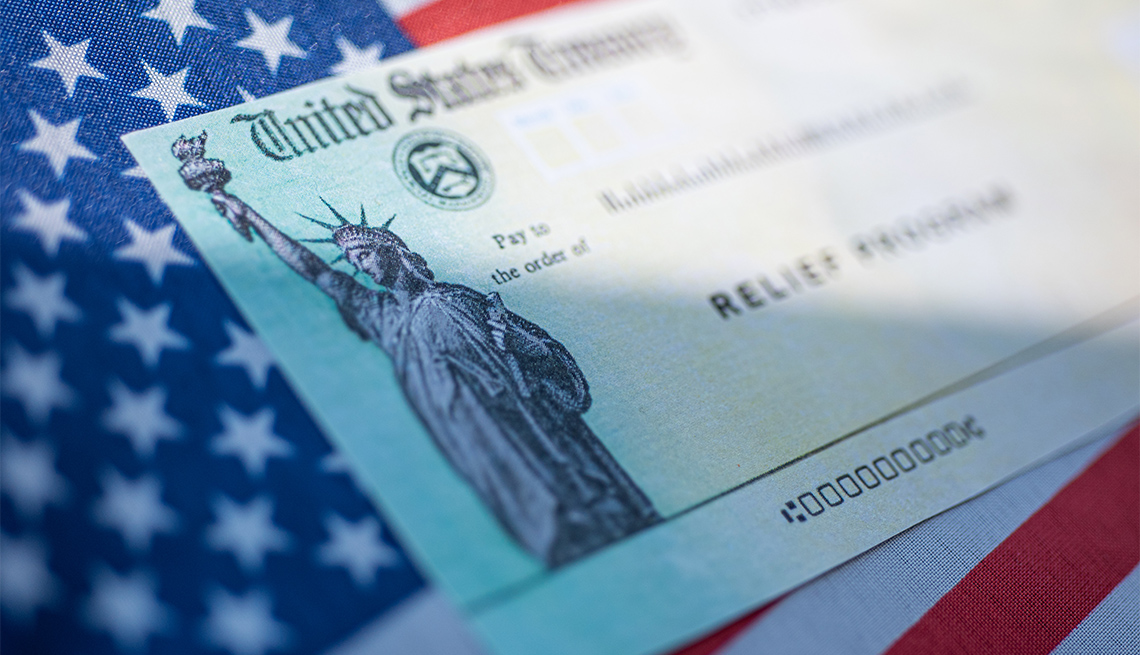 Bandera de Estados Unidos con un cheque de estímulo del Departamento del Tesoro