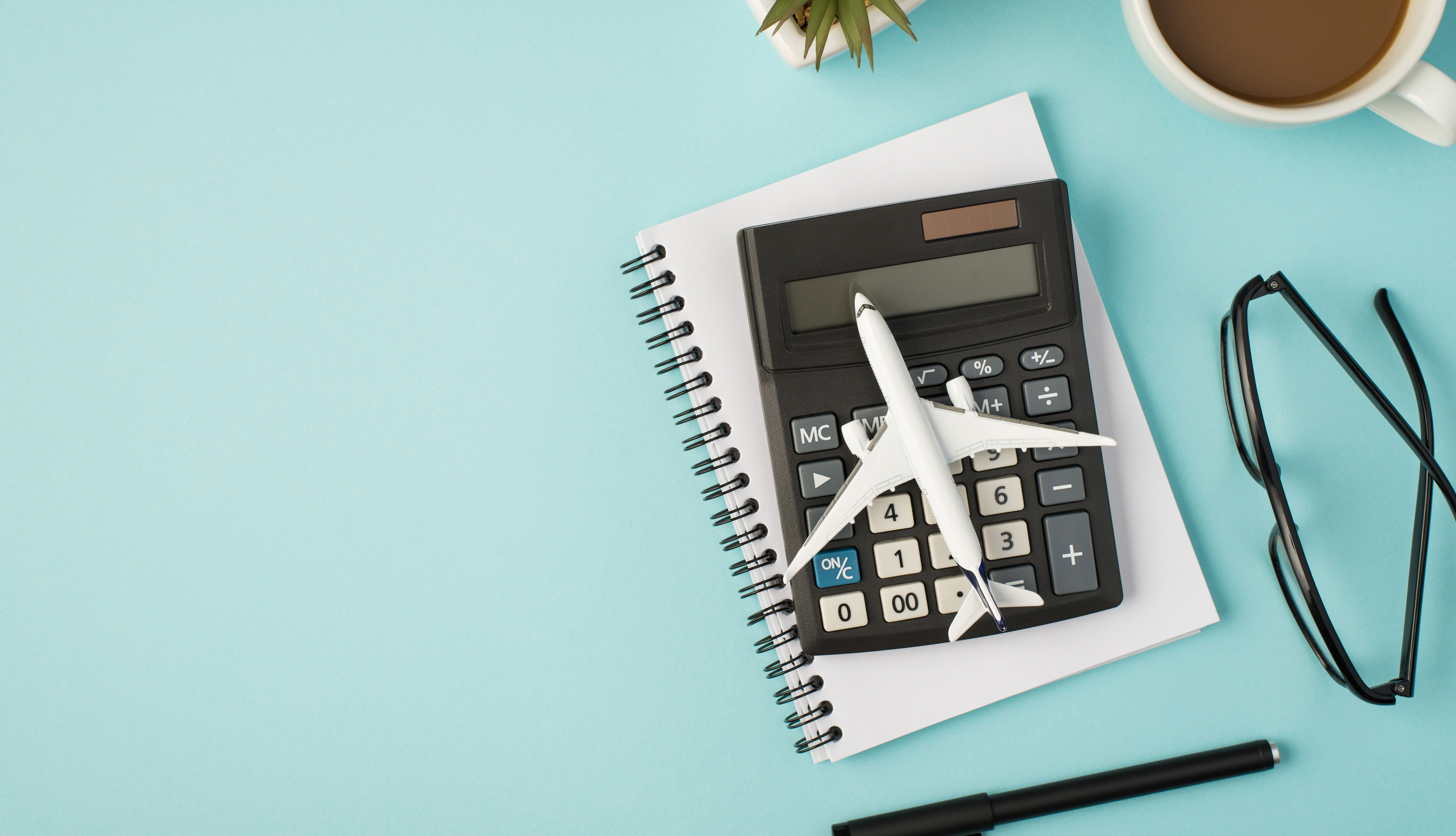 Jet de colección sobre una calculadora y un cuaderno de notas al lado de unas gafas y un café