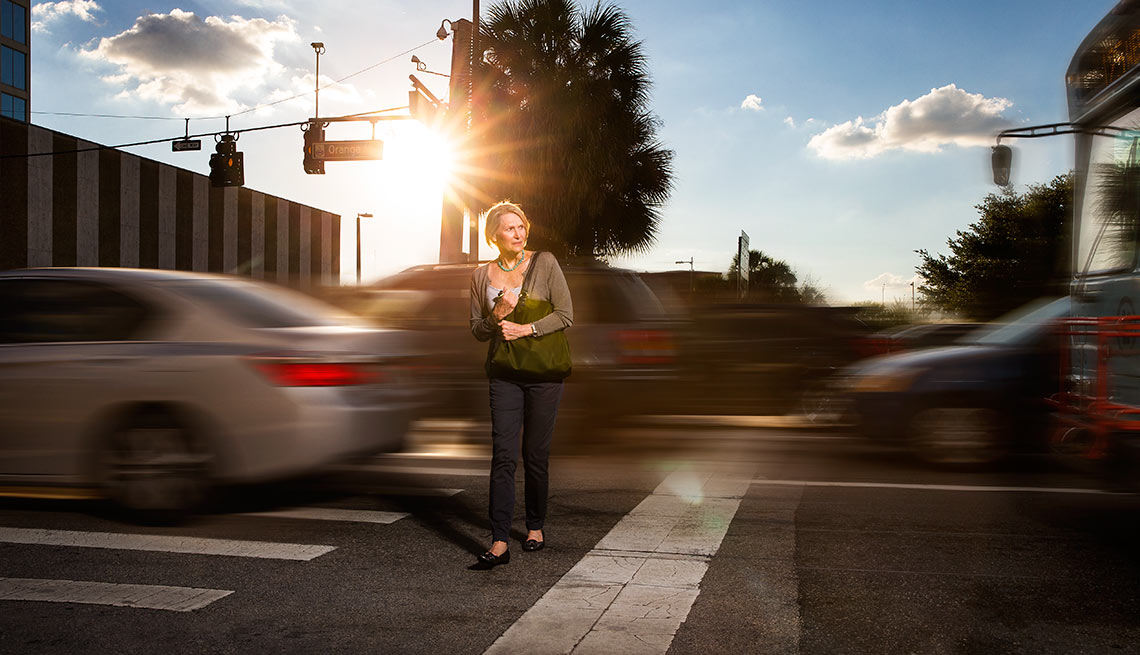 Woman walks cautiously across a highly trafficked street in Orlando, Pedestrian Safety