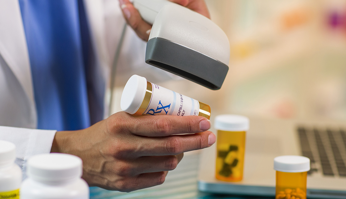 A pharmacist scanning a bottle of pills 