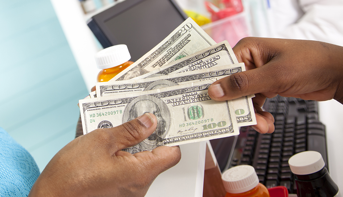 Persona paga con dinero por su medicamento recetado