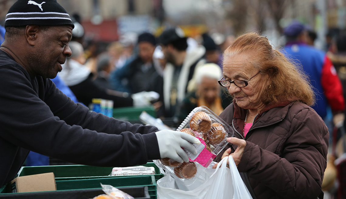 Mujer mayor recibe víveres gratis en un mercado