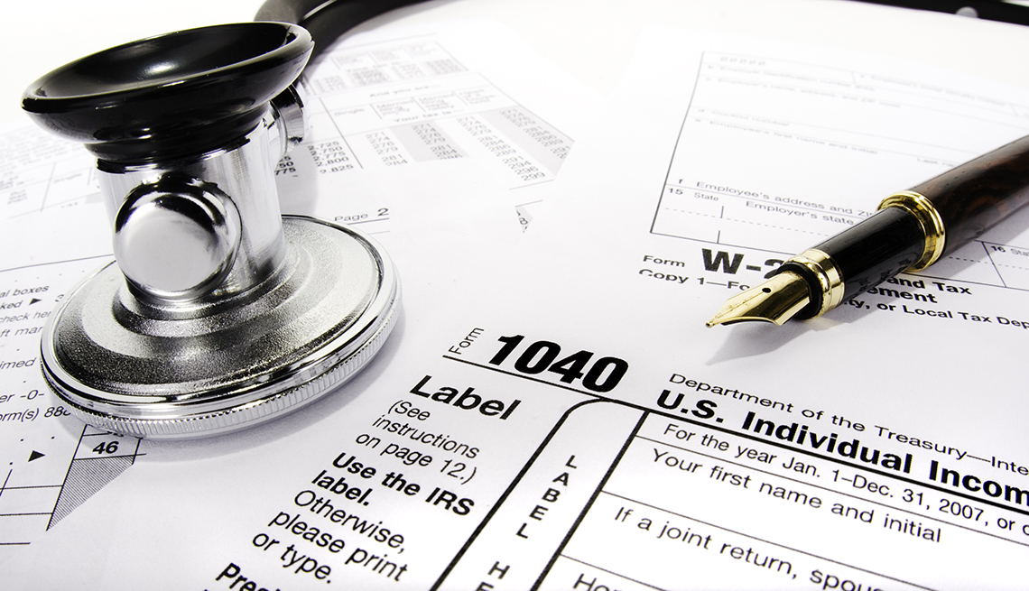 Formularios de impuestos con un bolígrafo y un estetoscopio