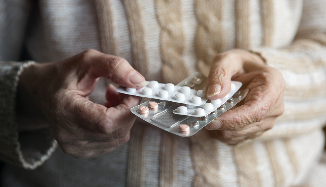 Persona sostiene varios tipos de pastillas empaquetadas
