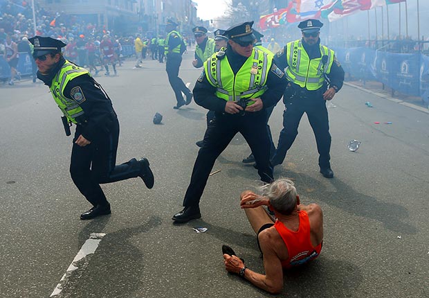 Bill Iffrig lies on the ground as police officers react to a second explosion at the finish line of the Boston Marathon in Boston. (John Tlumacki/The Boston Globe/AP)