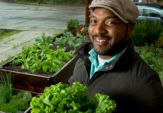 Author and chef Bryant Terry poses for a photograph with some freshly picked mustard greens from his home garden in Oakland, California.