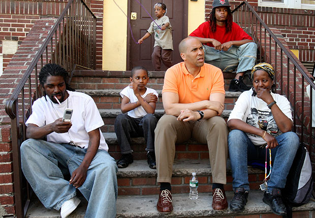 Newark mayor Cory Booker sits and listens in the courtyard of an apartment complex on Hawthorne Avenue in Newark.