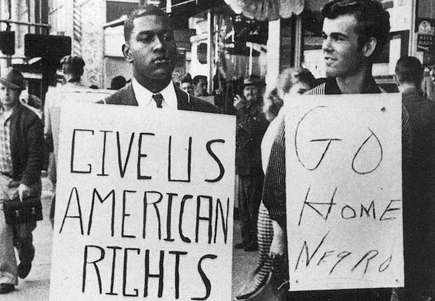 African American man holding sign that reads 'Give us American Rights' with white man holding sign that reads 