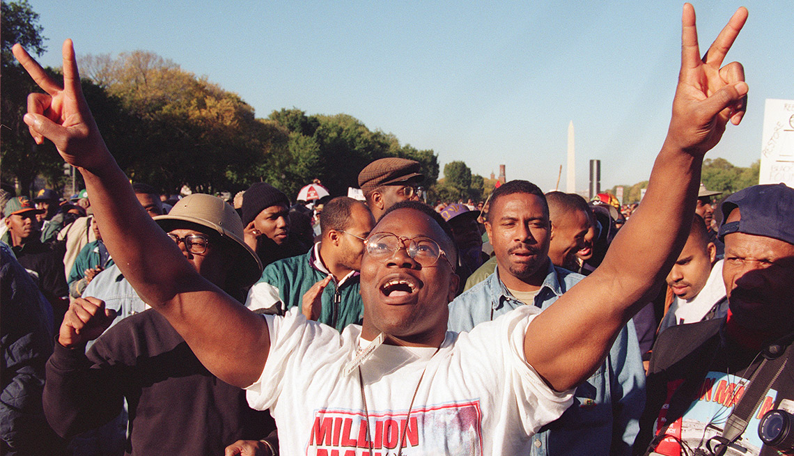 A man raises his hands in the air as he celebrates during Million Man March on the Mall, 16 October 1995, in Washington DC. 