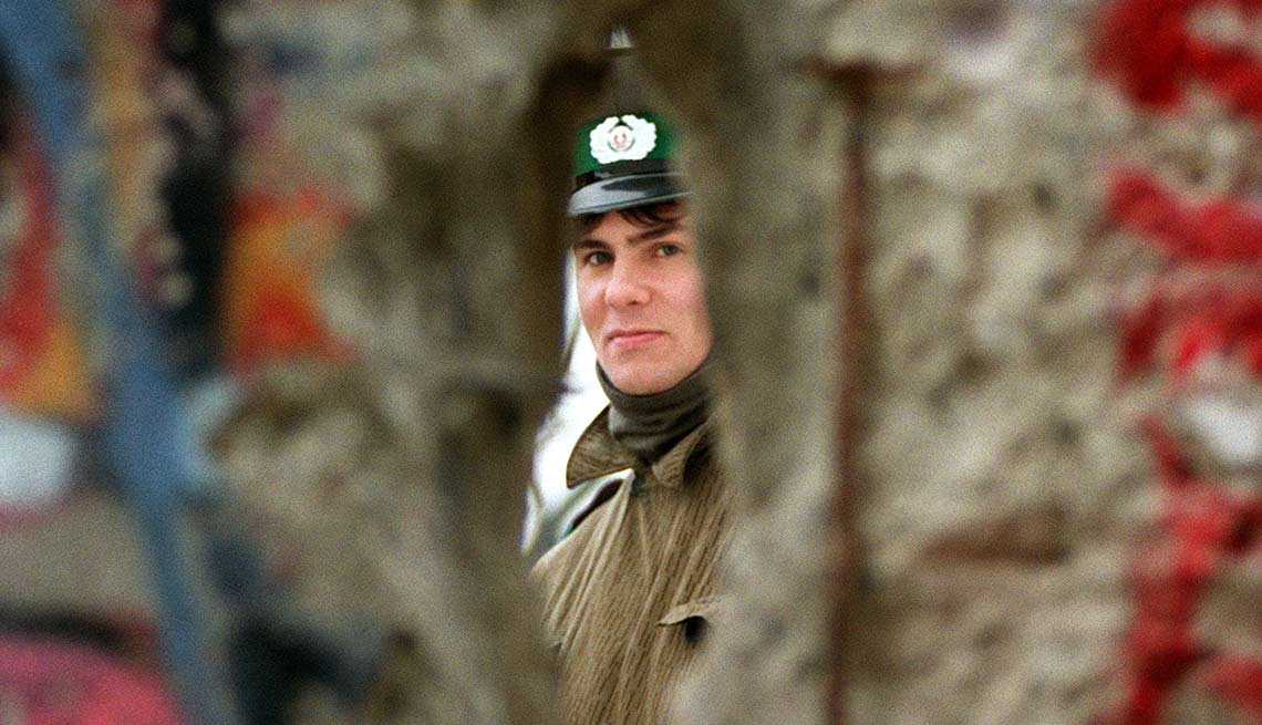 Persona mirando a través de un hueco en el muro de Berlín