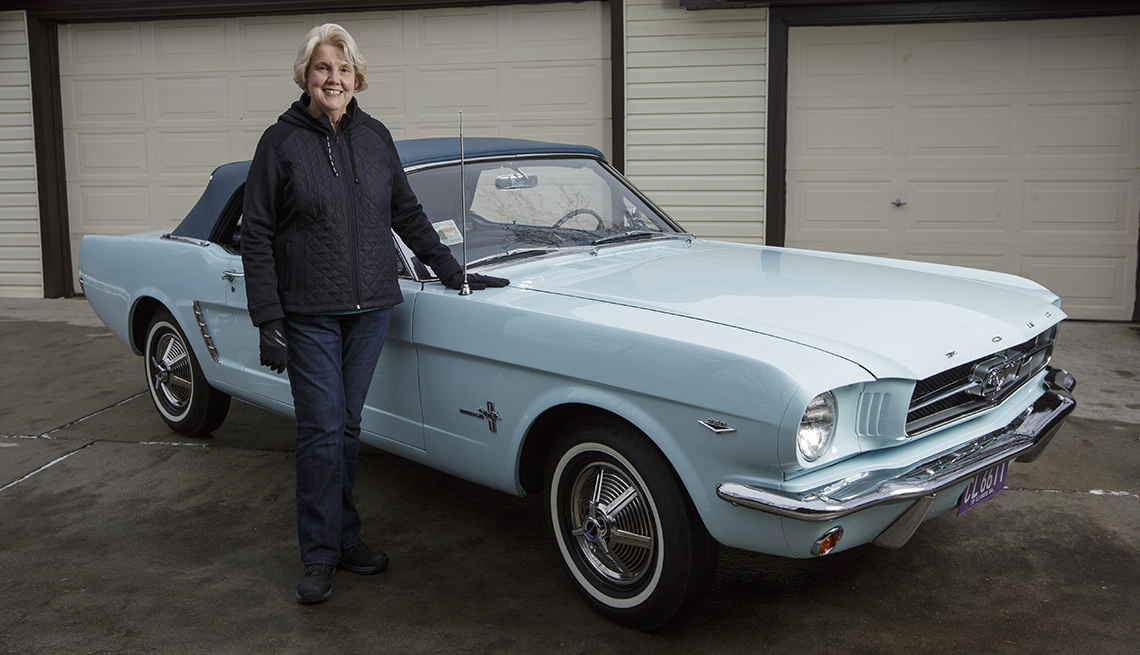 Gail Wise posa con su Ford Mustang convertible de color azul cielo frente a su garaje, donde se sentó durante 27 años antes de su restauración, en Park Ridge, Illinois