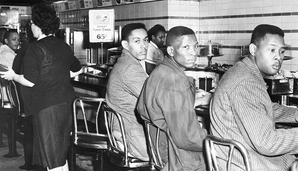 three men sitting at a lunch counter