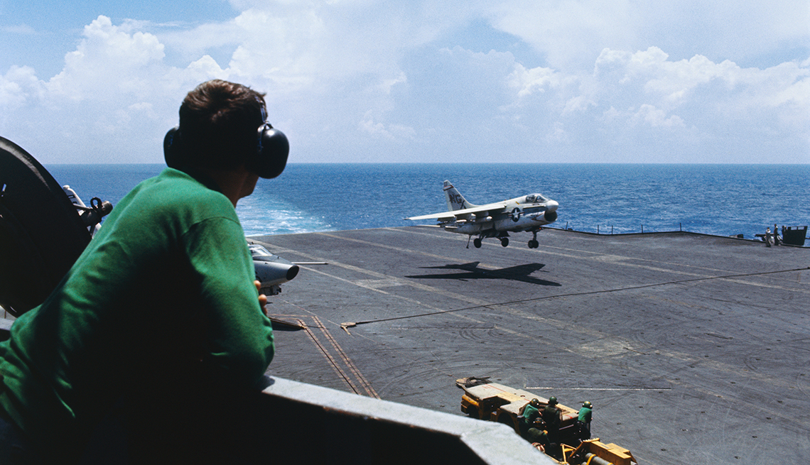 Hombre observa un avión desde un portaaviones de la marina de Estados Unidos