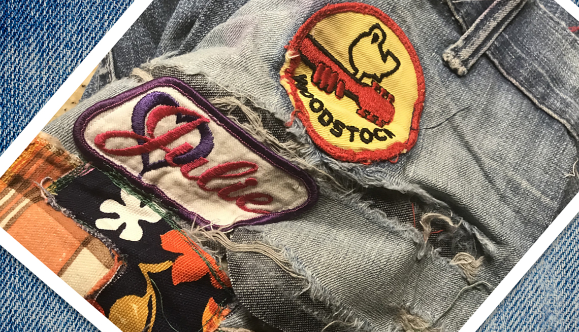 item 6 of Gallery image - snapshot of a pair of well worn jeans covered with various patches and rips. The patches include a Woodstock patch and another that spells out the name Julie