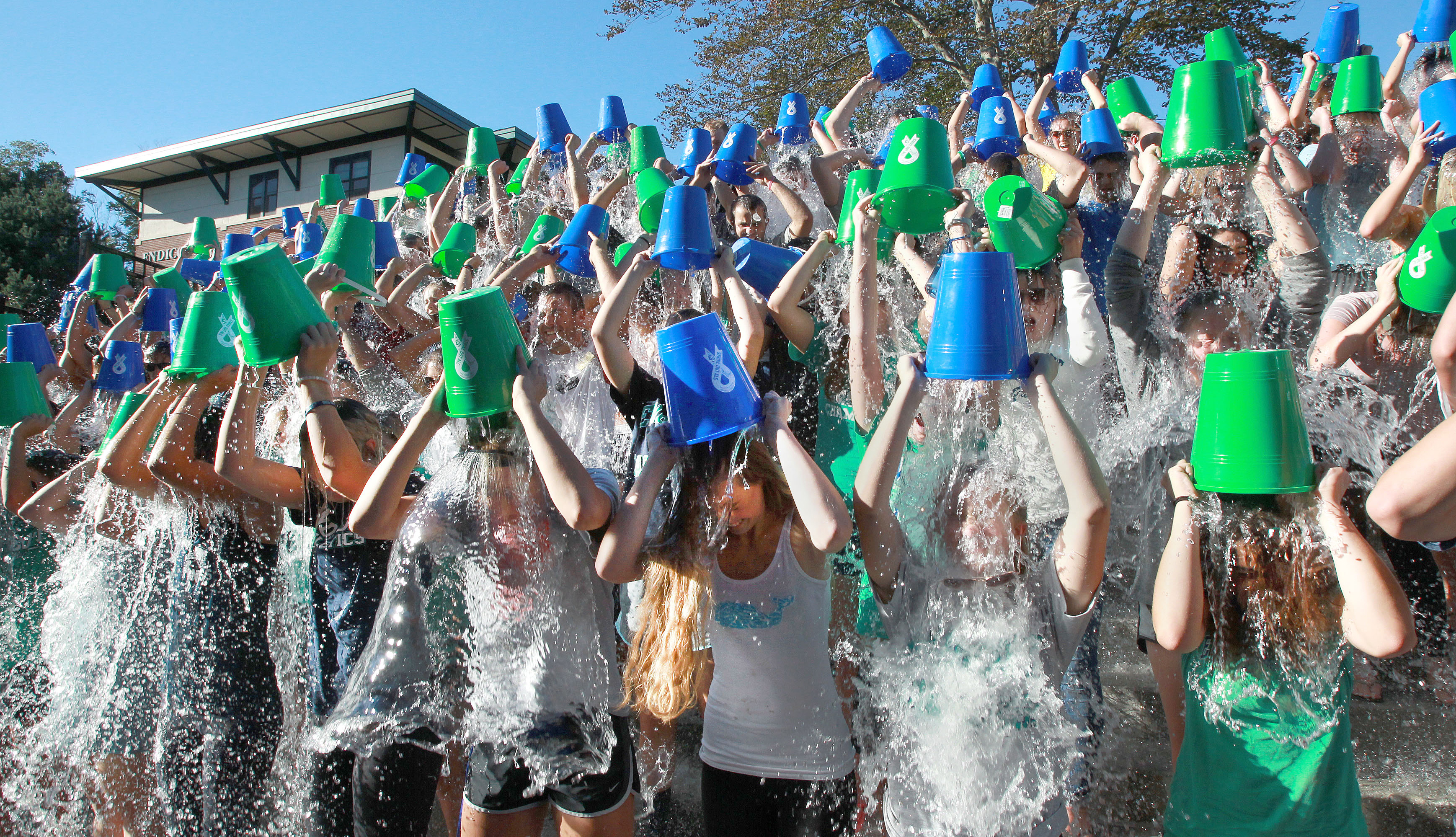 item 4 of Gallery image - a crowd of 30 plus people are all participating in an ice buck challenge and shown dumping buckets of ice water over their heads