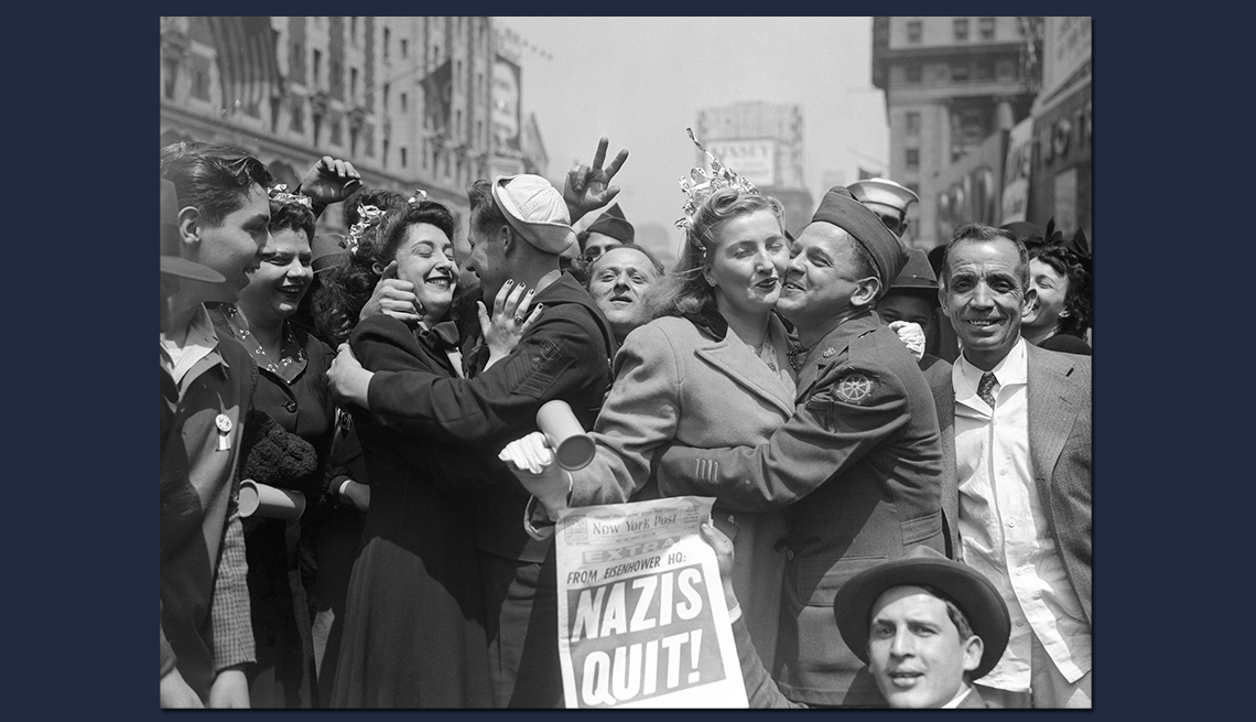 crowded street of returning soldiers and others embracing at the announcement of nazi defeat