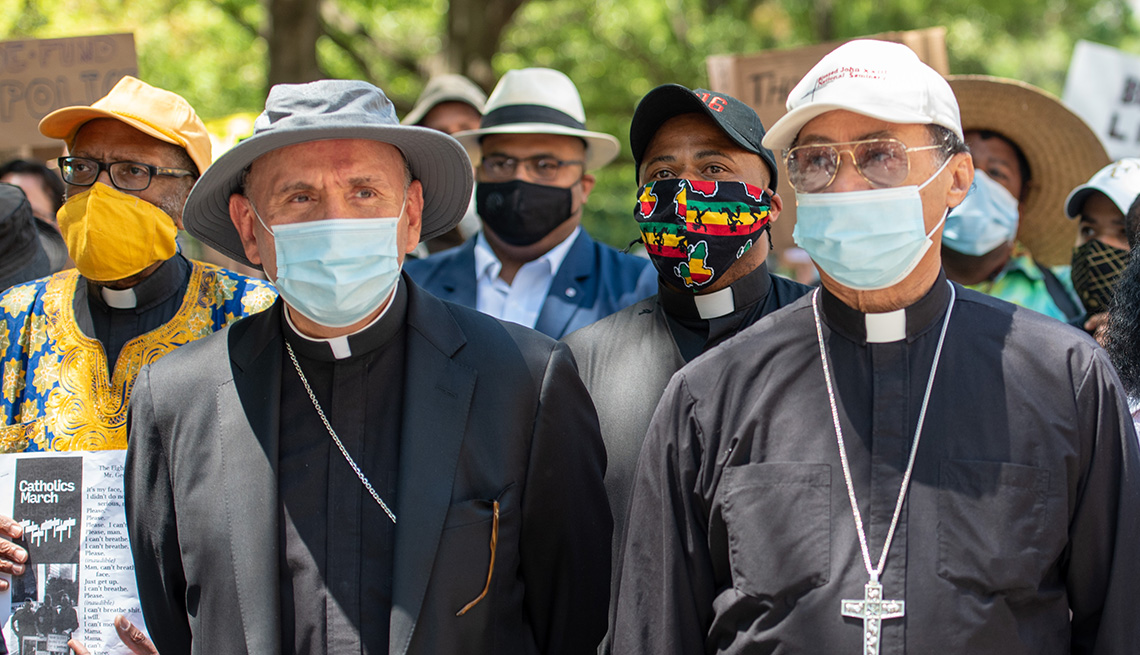 Un grupo de sacerdotes católicos con mascarillas participa en una marcha por la justicia racial