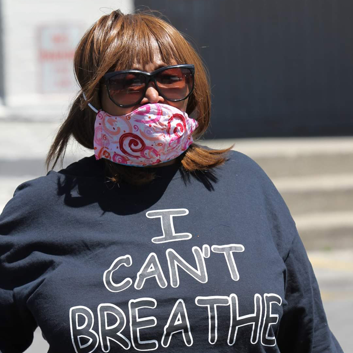 rhonda mathies wearing a face mask and shirt that says i cant breathe at a protest